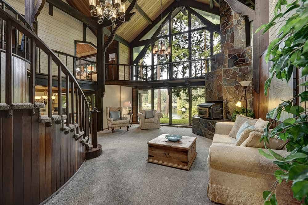 cabin style home with massive stone fireplace and wood panel walls